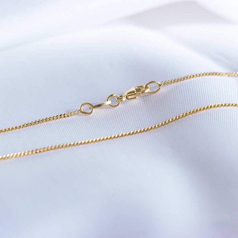 Met massief gouden fijne schakel ketting.