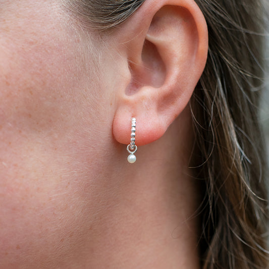 Zilveren oorbellen met kleine witte parel hanger.