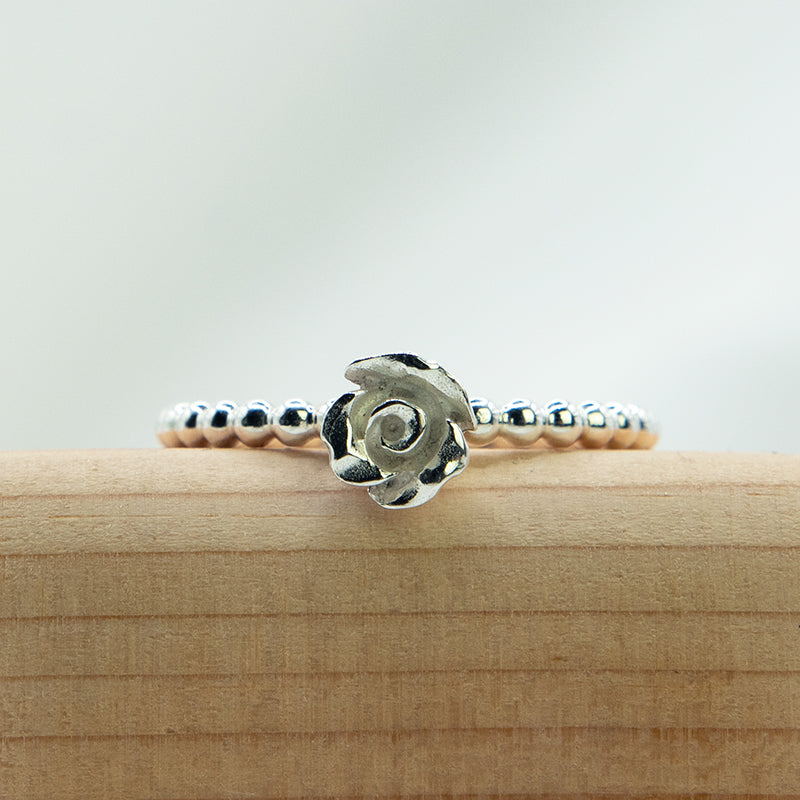 Zilveren bolletjes ring met zilveren roosje op de ring.