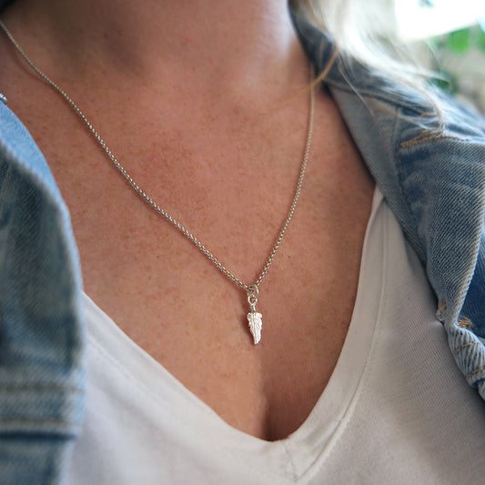 Zilveren veertjes bedel aan zilveren ketting.