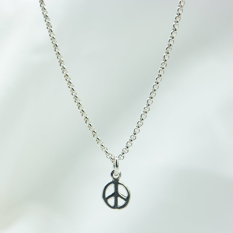 Zilveren peace hanger aan een zilveren ketting. handgemaakt zilveren peace bedel.