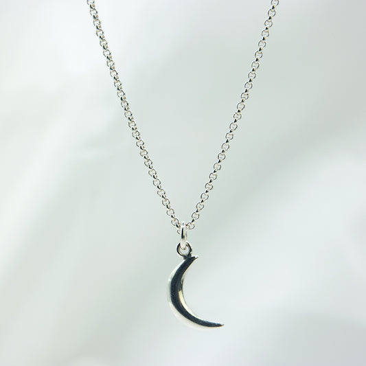 Zilveren maan hanger aan zilveren ketting.