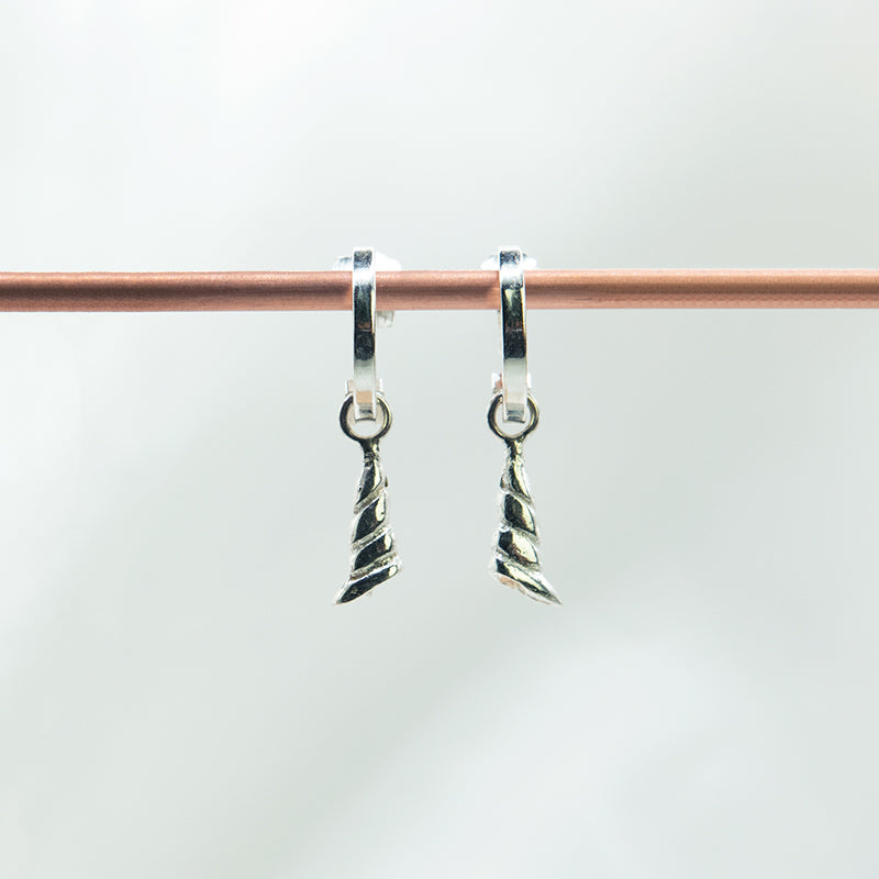 Zilveren schelp oorhanger aan gladde creolen.