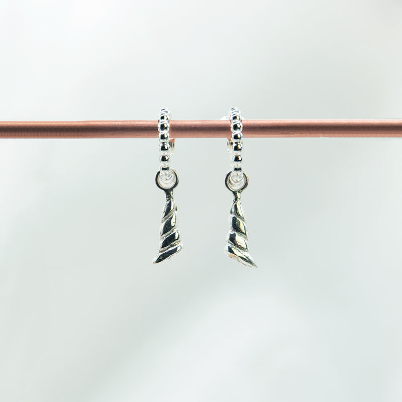 Zilveren schelp oorhanger aan pareldraad creolen.