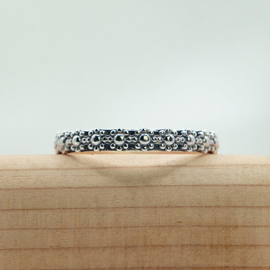 Zilveren bloem ring met zwarte afwerking.