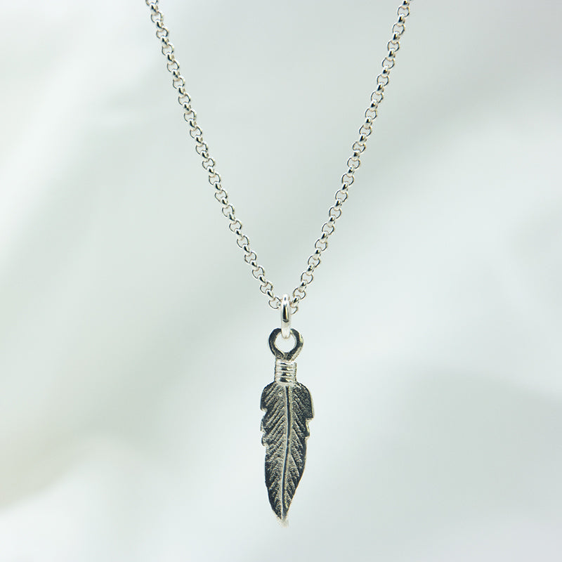 Zilveren veer hanger aan een zilveren ketting. Handgemaakt zilveren veer bedel.