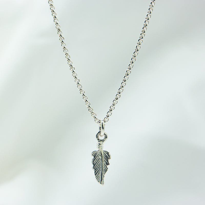 Zilveren veertjes hanger aan een zilveren ketting. Handgemaakt zilveren veertjes bedel.