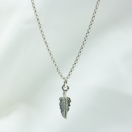 Zilveren veertjes hanger aan een zilveren ketting. Handgemaakt zilveren veertjes bedel.