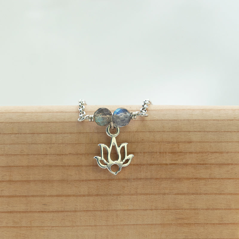 Zilveren armband voor vrouwen met Lotus bedel en aan weerskanten een prachtige Labradoriet kraal.