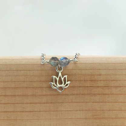 Zilveren armband voor vrouwen met Lotus bedel en aan weerskanten een prachtige Labradoriet kraal.