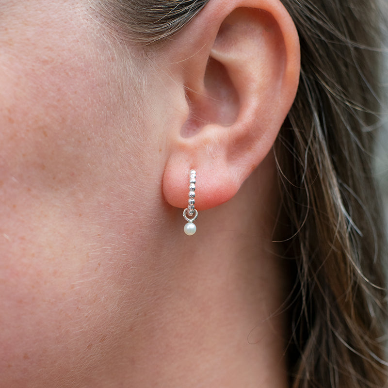 Zilveren oorbellen met kleine witte parel hanger. 