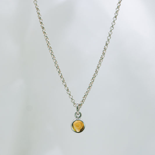 Zilveren ketting met 5 mm cobochon geslepen citrien in zilveren hanger met hart detail aan de achterkant.