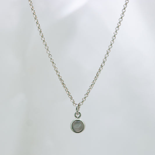 Zilveren ketting met 5 mm cabochon geslepen grijze maansteen in zilveren hanger met hart detail aan de achterkant.