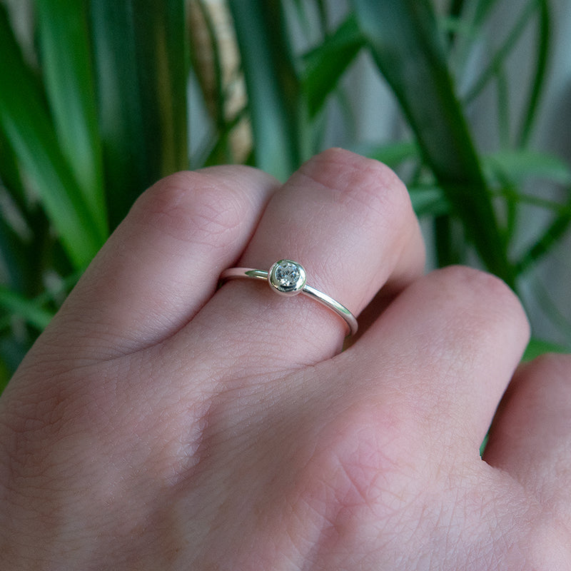 Zilveren ring met donutzetting en briljant geslepen steen.
