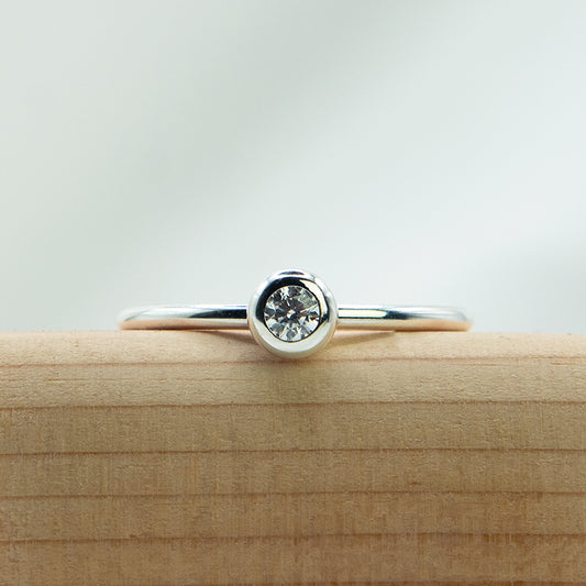 Zilveren ring met donutzetting en briljant geslepen steen.